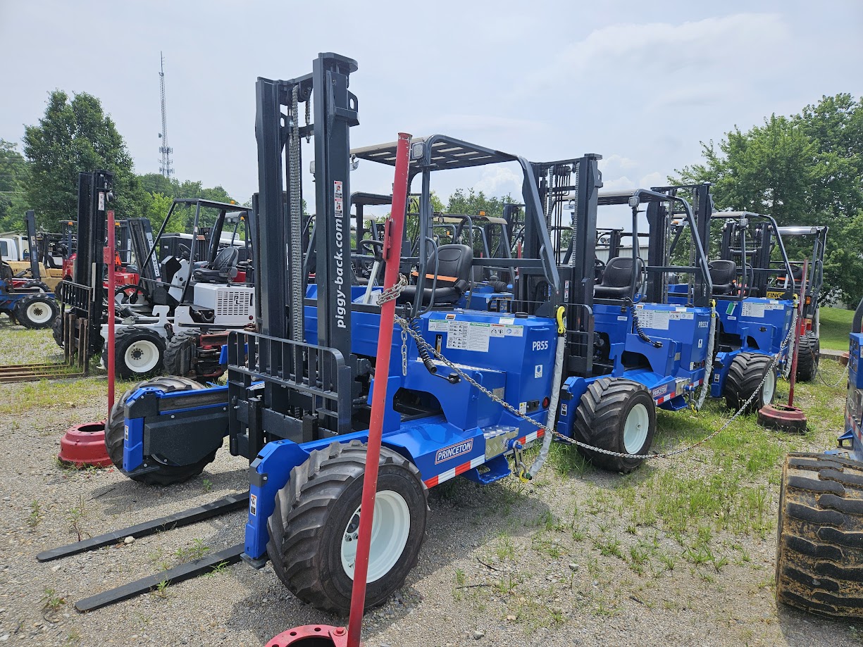 a line of blue princeton piggyback forklifts