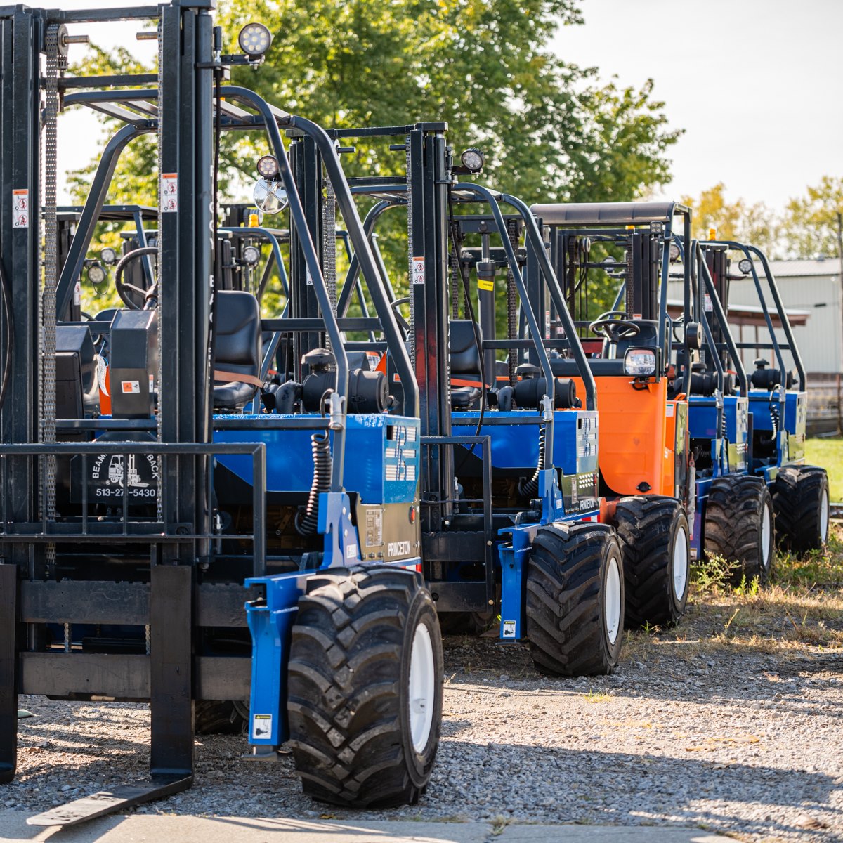 a line of blue forklifts